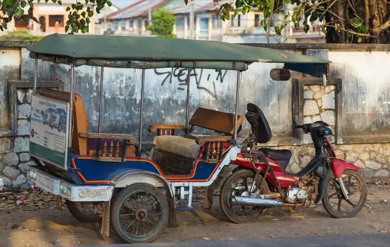 Een Cambodjaanse tuktuk (remorque) geparkeerd in een straat in Kampot
