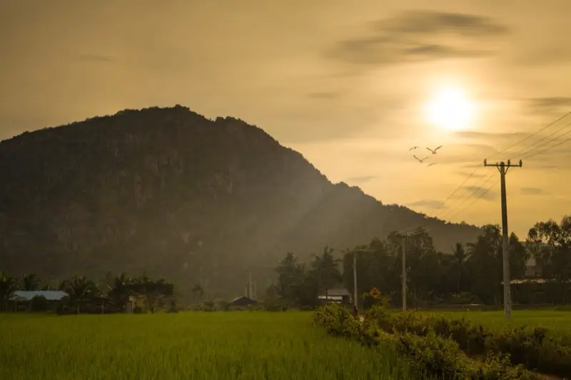 Sunset over rice fields and a hill near Kampong Trach, Kampot province